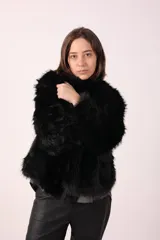 Campera de piel sintética color negro, de corte recto y mangas largas.