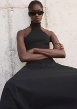 Top negro de punto fino con cuello halter y diseño entallado.