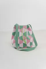 Bolso tipo bucket tejido con diseño geométrico en tonos rosa y verde, con cordón ajustable y correa ancha al tono para llevar al hombro o cruzado.