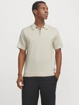 Polo de punto color beige con cierre de cremallera, mangas cortas y corte regular.