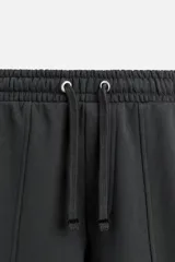 Pantalón de jogging negro, corte balloon fit, con cintura elástica ajustable con cordón, bolsillos laterales y trasero, costura frontal en las perneras y puños elásticos en los tobillos.