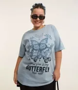 Remera celeste con estampado de mariposas y texto "Spread Your Wings Butterfly".