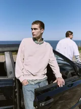 Buzo de manga larga y cuello redondo con fit holgado, confeccionado en tejido loop back sin cepillar 100% algodón.