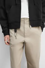Pantalón chino color verde militar, de corte recto, con bolsillos laterales y traseros de vivo. Cierre frontal con cremallera y botón.