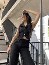 Conjunto sastrero negro de tela barbie, compuesto por un chaleco corto con botones y un pantalón palazzo de tiro alto.