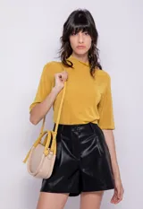 Top color mostaza de manga 3/4 y cuello polera, confeccionado en tela con pequeños destellos metálicos.