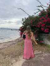 Falda larga tejida a rayas rojas y blancas, con pretina elástica y tajos laterales profundos.