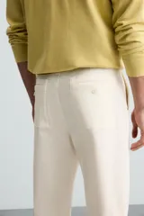 Pantalón chino color crema, de corte recto y largo a la altura del tobillo.