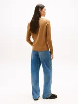 Sweater de punto color camel con cuello barco y logo de la marca bordado en el pecho.