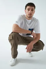 Pantalón cargo negro de canvas, tejido de algodón grueso, con tiro medio, pasa cintos y cuatro bolsillos cargo.