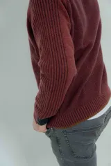 Sweater marrón de lana lambswool con cuello redondo y mangas largas. Presenta un diseño de punto texturizado en el cuerpo y mangas con detalle de punto acanalado en hombros y puños.