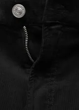 Pantalón de pana negro, de corte wideleg, tiro medio y cinco bolsillos. Cierre frontal con cremallera y botón, trabillas en la cintura.