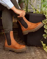 Bota de cuero color marrón con elásticos laterales negros, caña baja y suela negra artesanal de neolite.