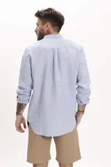 Camisa celeste de lino, de corte clásico, manga larga y cuello abotonado.