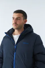 Campera puffer azul marino para hombre, con capucha ajustable, cuello alto, bolsillos con cierre y logo en goma.