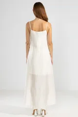 Vestido largo color crema de lyocell, poliamida y lino, con breteles finos, escote recto, lazos en los costados y forro hasta arriba de las rodillas.