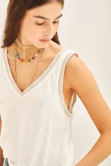 Remera blanca de lino y viscosa con moldería línea A y detalles en rib con lurex en escote y sisas.