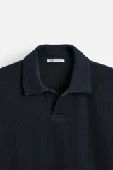 Polo azul marino de manga larga con cuello solapa, abertura frontal y acabado en rib.