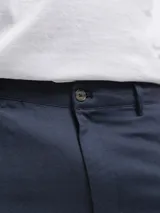 Bermuda de lino color negro, corte recto, con bolsillos laterales y cierre frontal.