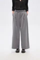 Pantalón gris de poliéster, de corte baggy, tiro alto, con pinzas frontales y bolsillos laterales.