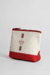 Necessaire rectangular de tela color crudo con base y cierre en color rojo. Estampado frontal con el texto "The Beach Club Lolita" en color rojo.