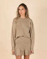 Pollera corta dorada de tejido de punto con lurex y volado en el ruedo.