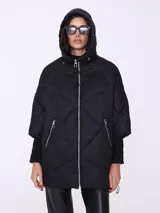 Campera negra acolchada con capucha, cierre frontal y bolsillos laterales con cierre. Tiene mangas 3/4 con puño de tricot.