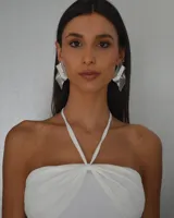 Aros colgantes plateados con forma geométrica irregular y diseño texturizado.