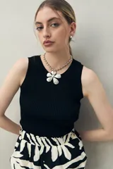 Musculosa negra de tejido acanalado con escote redondo y calce al cuerpo.