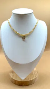 Gargantilla de cristalitos facetados color amarillo con dije de punto de luz blanco.