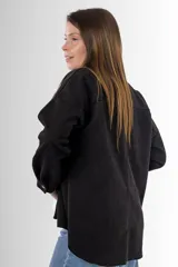Camisa negra de gamuza sintética, corte amplio y largo asimétrico.