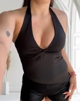 Top negro con escote halter y detalle de nudo en el centro del busto.