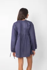 Vestido corto azul con escote con cordones, mangas largas abullonadas y corte evasé.