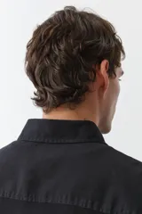 Sobrecamisa negra de manga larga con cuello inglés, tapeta lisa, canesú en la espalda y bolsillo superior de parche.