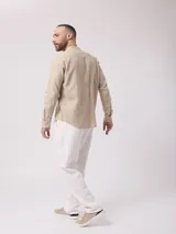 Camisa de manga larga color crudo, confeccionada en lino. Presenta cuello mao y cierre frontal con botones. Marca La Dolphina.