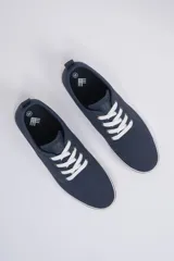 Zapatillas acordonadas de lona color azul marino con cordones blancos y suela blanca.