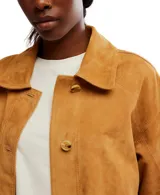 Campera color marrón de gamuza, con botones frontales, dos bolsillos de parche, abertura en la espalda y corte holgado.