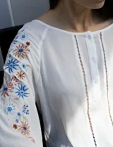 Blusa azul con escote redondo, mangas 3/4 con bordado floral y abertura central con botones. Marca Forgotten Grace.