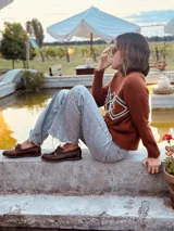 Mocasines náuticos de cuero marrón oscuro con cordones de cuero y suela de goma blanca.