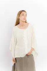 Blusa color ladrillo de lino con cuello redondo y mangas largas amplias. Presenta detalle de apliques rectangulares verticales en el frente.
