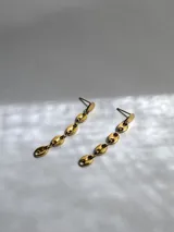 Par de caravanas colgantes doradas con forma de granos de café.