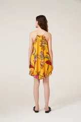 Vestido corto amarillo con estampado de flores, breteles finos y cuello redondo.