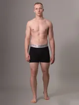 Pack de tres bóxer brief negros de algodón con cintura elástica plateada con el logo de Calvin Klein.