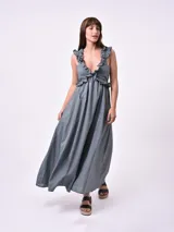 Vestido largo blanco con breteles finos y volados en el escote.