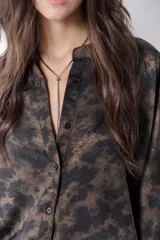 Camisa marrón chocolate con estampado abstracto, cuello mao, mangas 3/4 con puños y cierre frontal con botones.