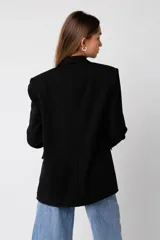 Blazer negro de corte oversize, con solapas y cierre frontal con botón.