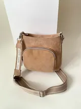 Cartera tipo bandolera color tostado, hecha 100% en cuero con bolsillo con fuelle y cierre metálico en el frente. El cerramiento principal es mediante un cierre metálico. Cuenta con una correa desmontable, hecha en cuero con detalle de cinta de tela con logo Cilento y tira de tela combinada regulable. Todos los cierres son de la marca YKK. En su interior, tiene un bolsillo con cierre enmarcado en cuero y un bolsillo plaqué. El forro es una loneta reforzada.