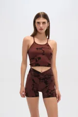 Conjunto deportivo gris con estampado abstracto negro, compuesto por un top ajustado de breteles finos y cuello redondo, y un short de tiro alto con cintura cruzada.