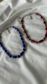 Collar corto de cuentas rojas con forma de barril alternadas con cuentas plateadas redondas.