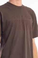 Remera unisex color marrón con cuello redondo y estampado frontal con el texto "Seventy Water" y dibujos de un pez, una estrella, una cruz y un caballo.